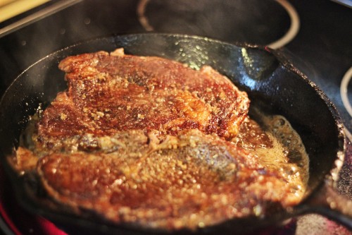 chuck eye steaks searing in a skillet