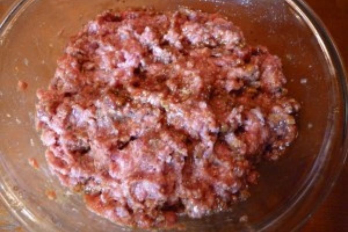 Raw meatloaf mixture in a glass bowl.