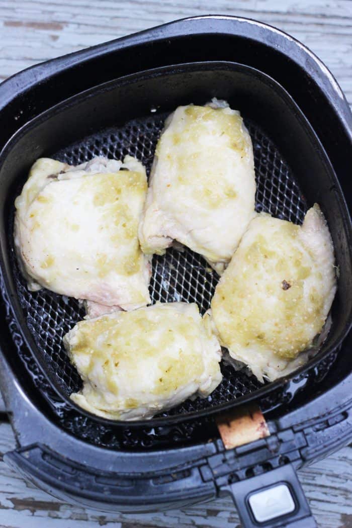 pressure cooked chicken thighs in an air fryer basket