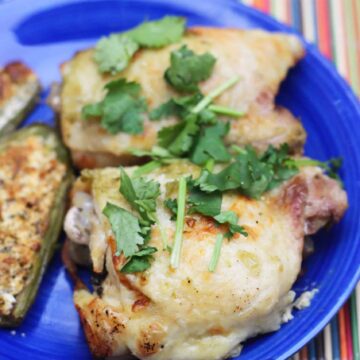 crispy keto instant pot chicken thighs garnished with cilantro and served on a blue plate