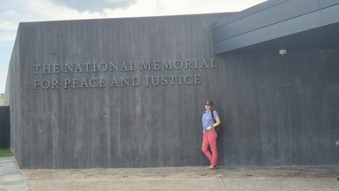 standing beneath the national memorial for peace and justice sign