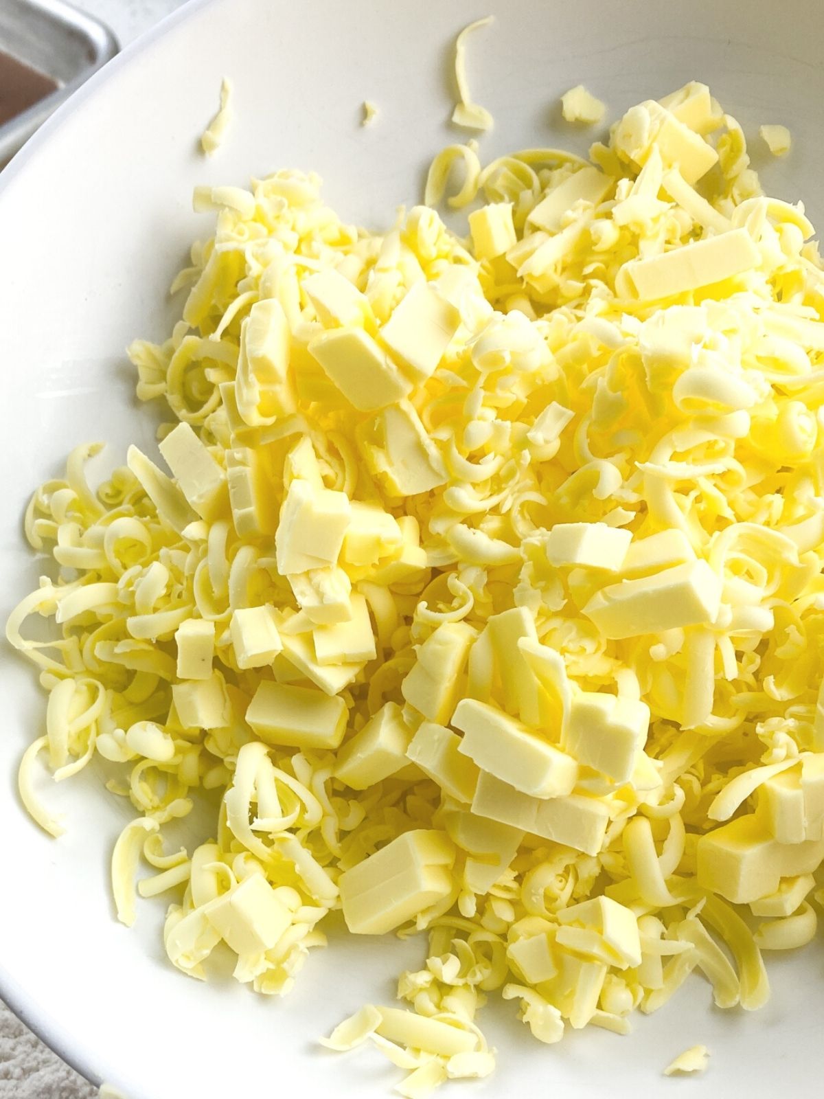 a pile of cold grated butter shavings on a white plate.