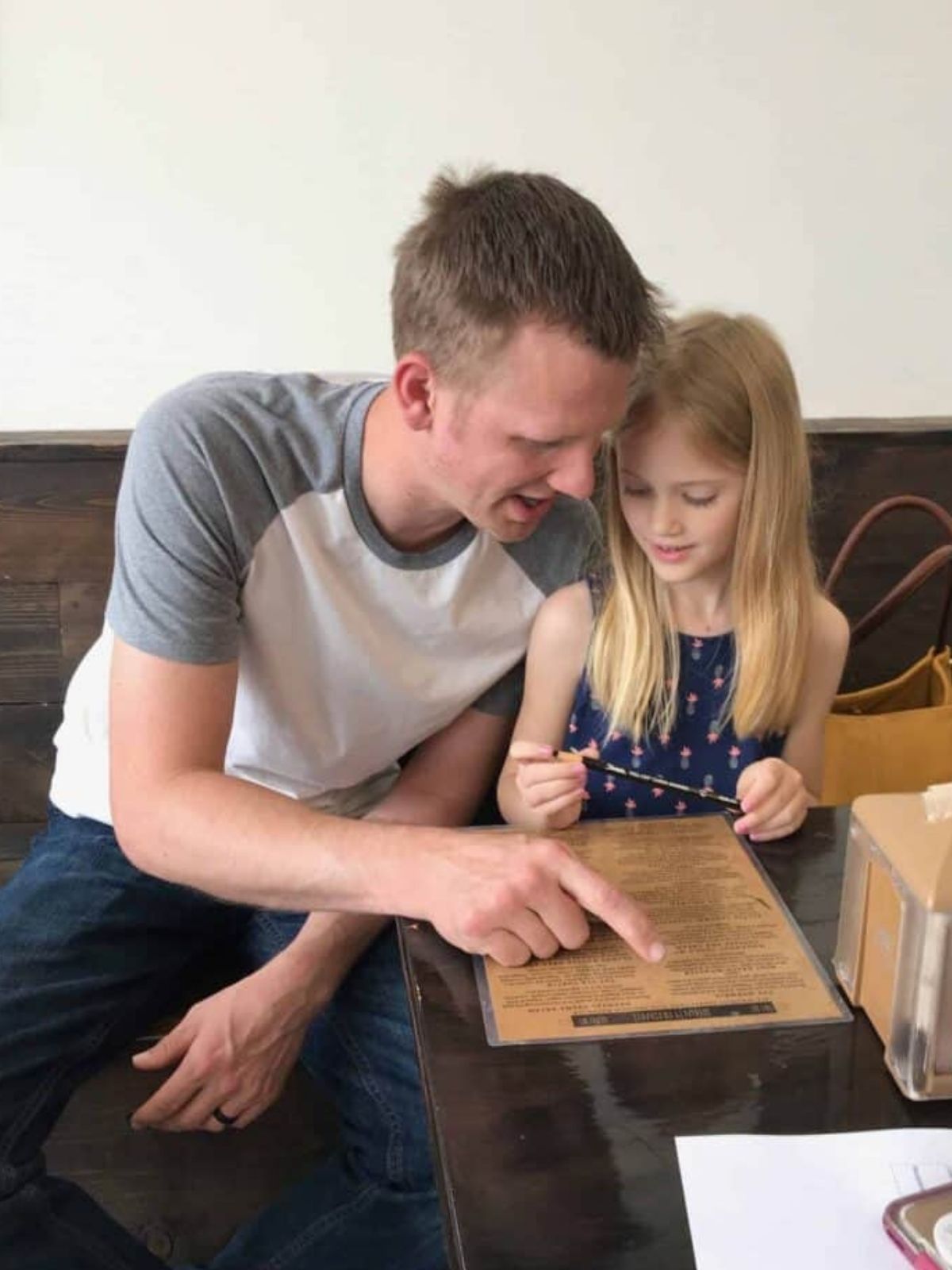 a father and daughter look over the menu at the yard milkshake bar