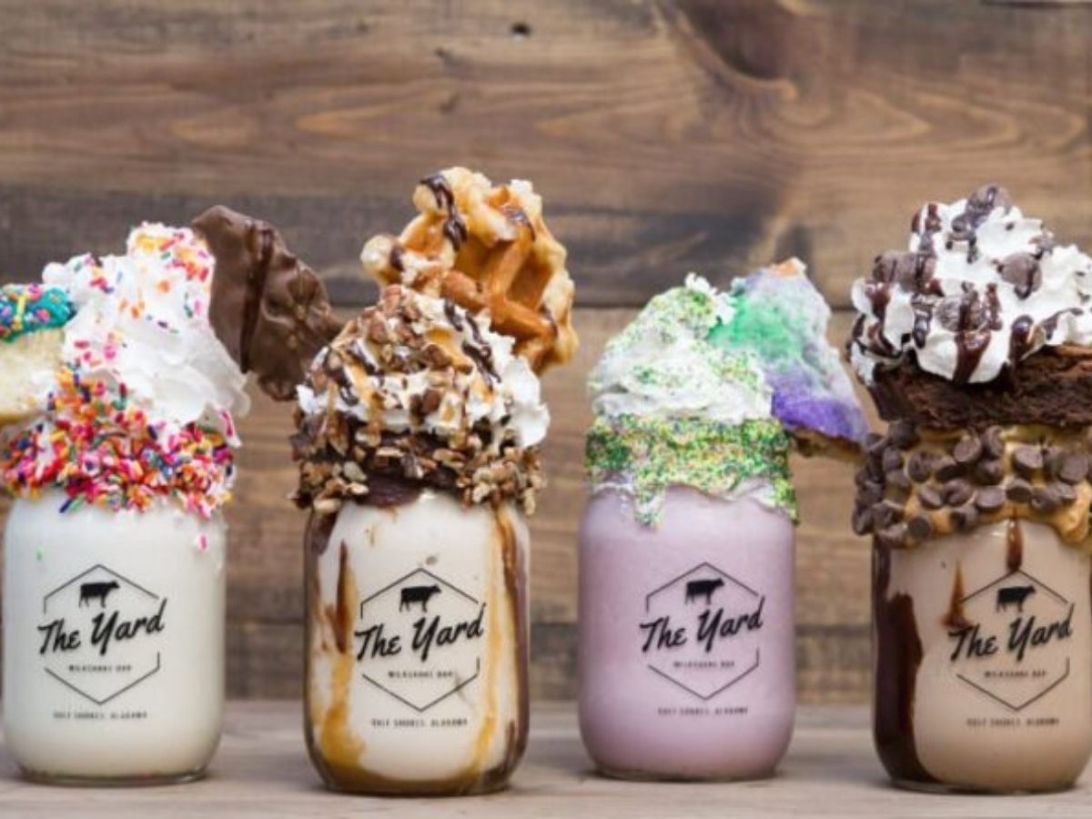 a lineup of four different milkshakes from the yard milkshake bar in Gulf shores, each served in a mason jar