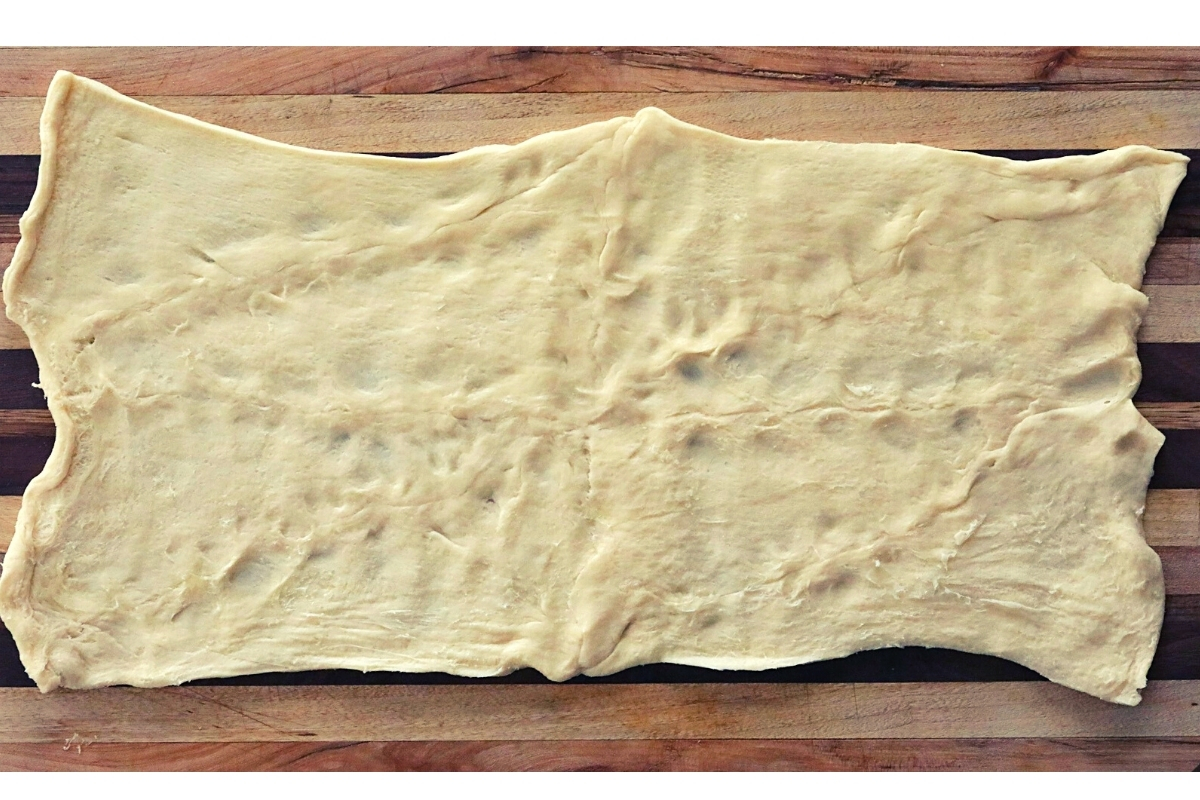 A rectangle of crescent roll dough with the perforations closed after pinching.
