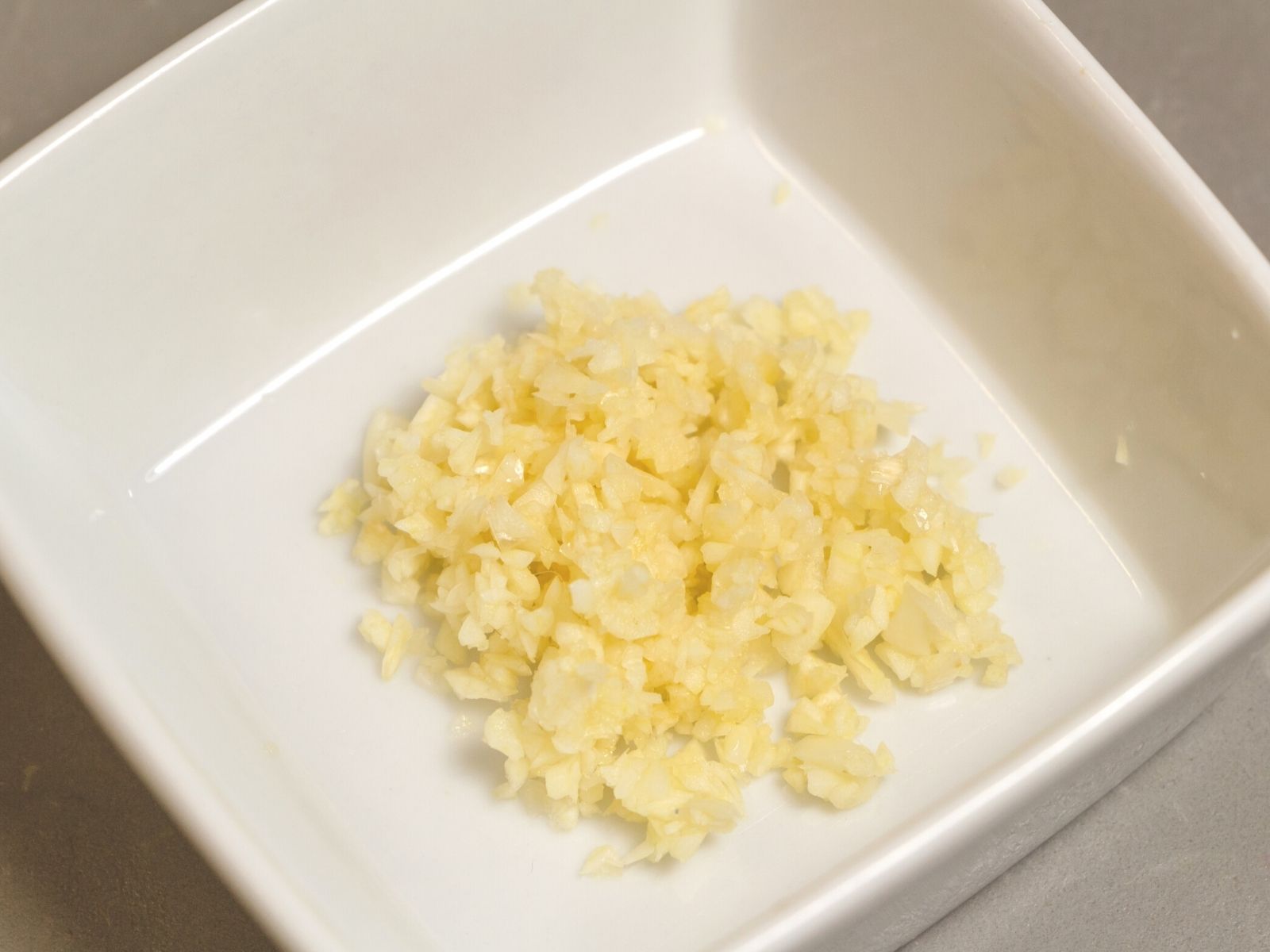 Minced garlic in a white bowl.