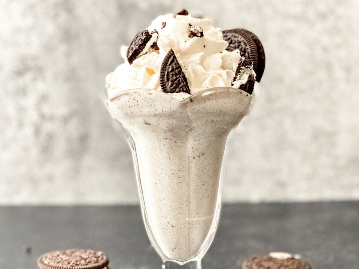 A homemade Oreo McFlurry in a parfait glass topped with whole oreo cookies as a garnish.