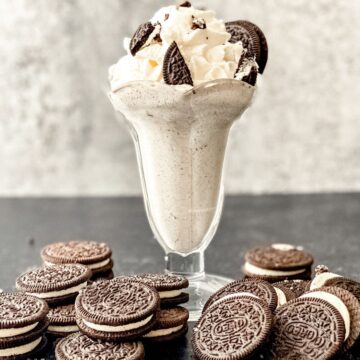 A homemade Oreo McFlurry in a parfait glass topped with whole oreo cookies as a garnish.