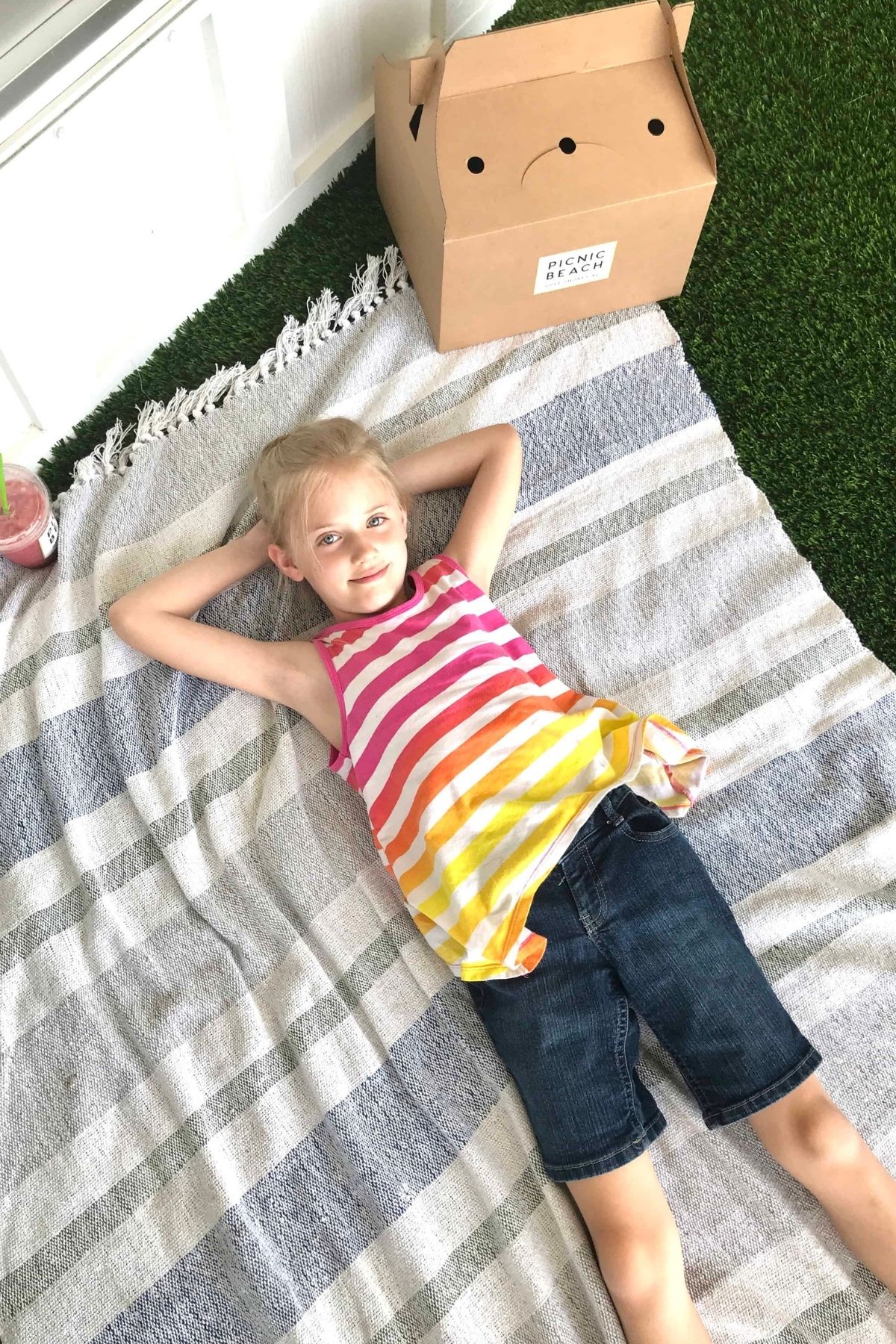 Little girl relaxing on a picnic blanket at Picnic Beach restaurant.