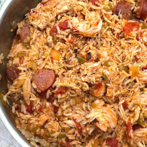 A pan of finished jambalaya with visible andouille sausage, shrimp, chicken, and rice.